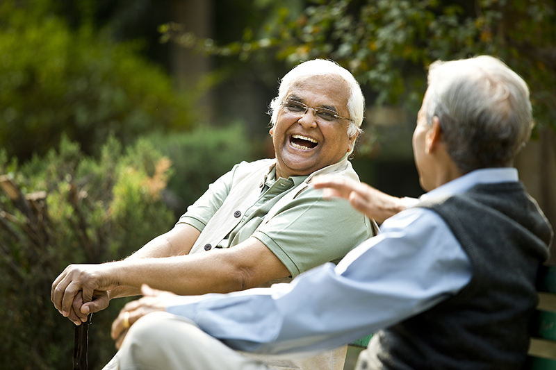 Smiling Senior Aged Men Having A Friendly Discussion About The Cost Of Senior Living